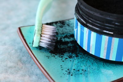 Close-up of toothbrush in tray by bottle on table