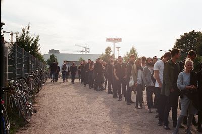 People waiting in queue against sky