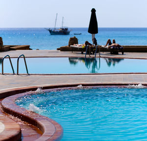 Swimming pool in sea against clear sky