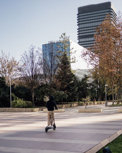 Madrid city downtown business area with a guy riding a electric scooter