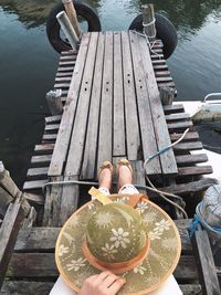 High angle view of woman sitting on wooden boat at lake