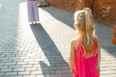 Rear view of woman standing on footpath