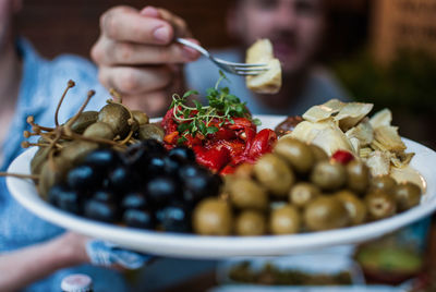 Cropped image of man taking food from plate