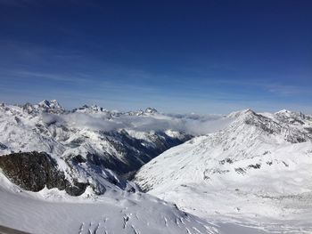 Scenic view of snowcapped mountains against blue sky