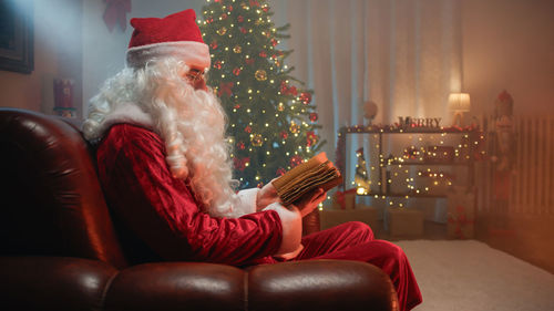 Rear view of woman sitting on sofa at home