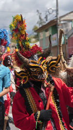 Portrait of man dressed as a red devil parading in the diablada pillarena in pillaro city - ecuador