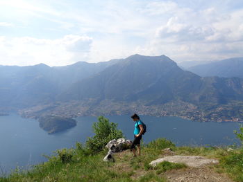 Woman standing with dog on mountain by lake como