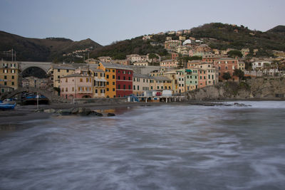 Buildings by sea against sky in town