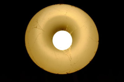 Directly below shot of illuminated light bulb against black background