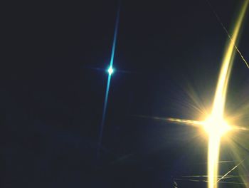 Low angle view of illuminated lights against blue sky