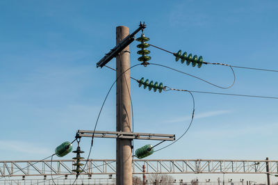 Low angle view of electricity pylon against sky