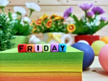 Close-up of colorful blocks with friday text on stacked papers over table