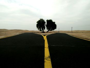 Road amidst trees against sky