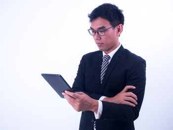 Young man using smart phone against white background