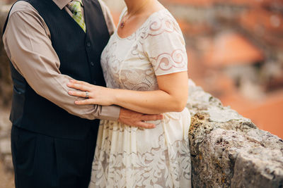 Midsection of couple holding hands