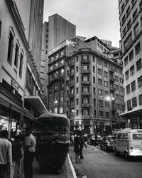 Rear view of people walking on road in city