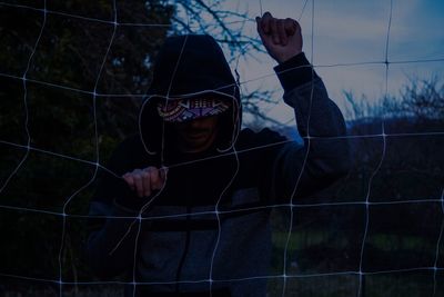 Man holding net while standing at park during dusk