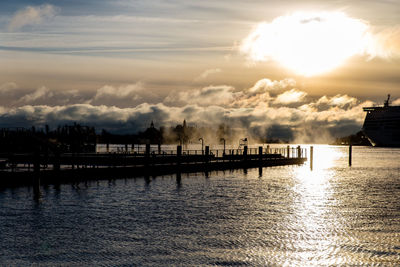 Pier over sea against sky during sunset