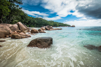 Scenic view of rocks in sea against sky