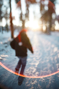 Blurred motion of woman walking on snow covered trees