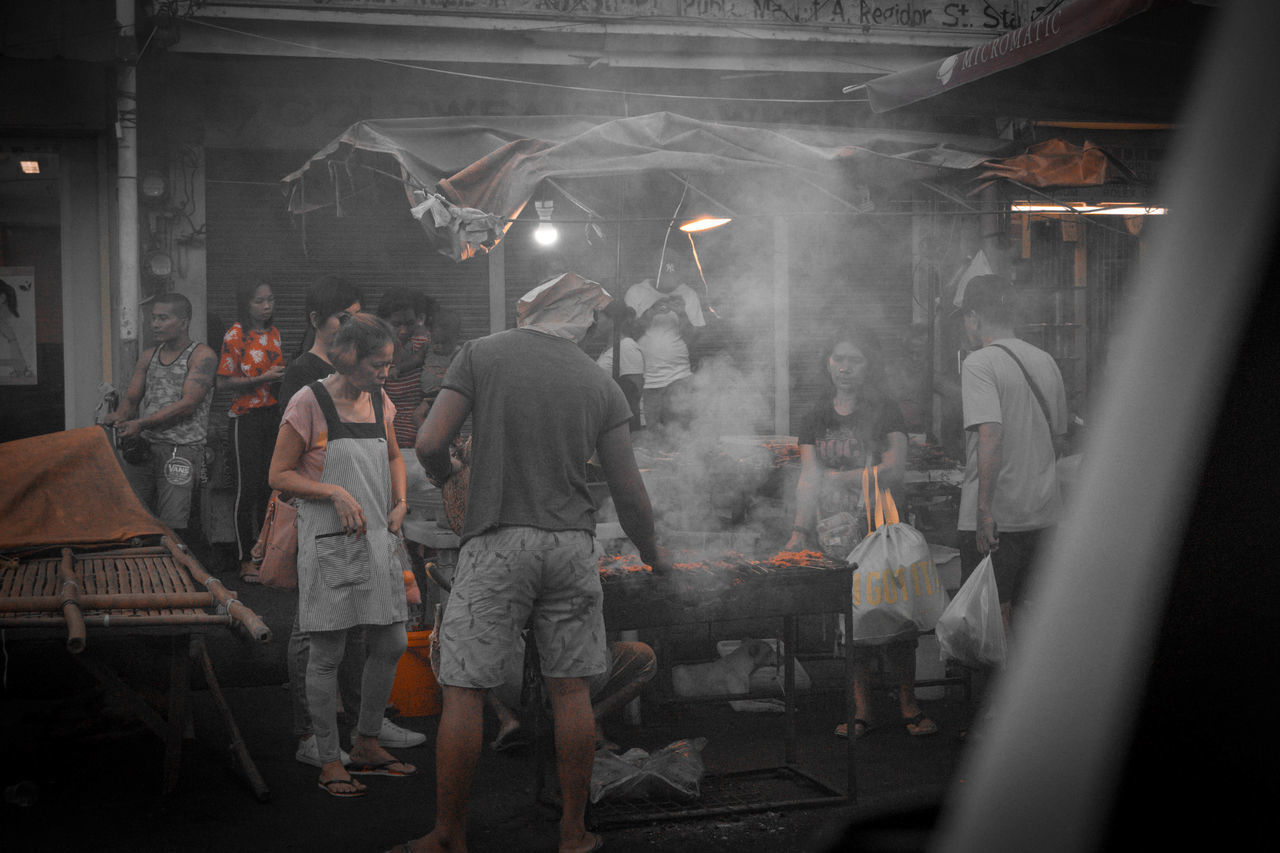 REAR VIEW OF PEOPLE STANDING IN THE DARK