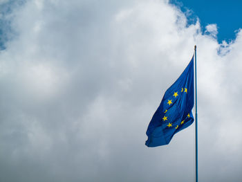 Low angle view of flag against blue sky