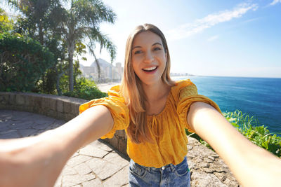 Beautiful smiling young woman takes selfie on belvedere terrace in rio de janeiro, brazil.