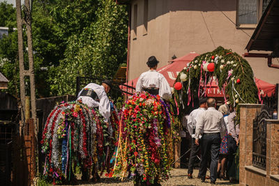 Rear view of people walking by building