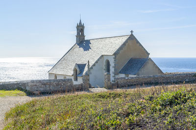 Traditional building by sea against sky