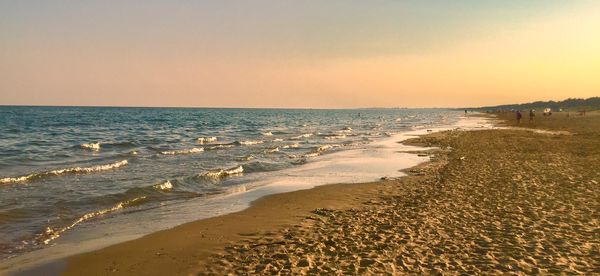 Scenic view of beach against clear sky during sunset