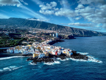 High angle view of townscape by sea against sky