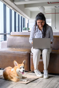 Young man using laptop while sitting on sofa at home