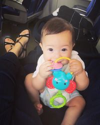 Close-up portrait of cute baby girl sitting in bus