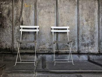 Empty chairs against wall in old building