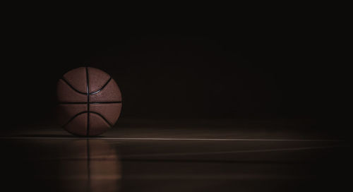 Low angle view of basketball hoop against dark background