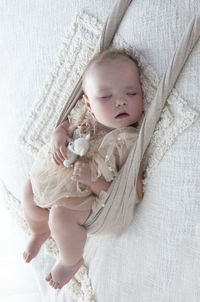 High angle view of cute baby girl lying on bed