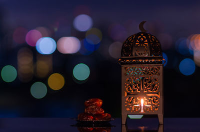 Lantern and small plate of dates fruit with night sky for the holy month of ramadan kareem.