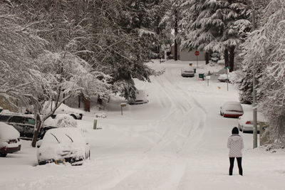 Man walking on snow covered landscape during winter