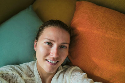 Woman relaxing on the colorful pillows smiling