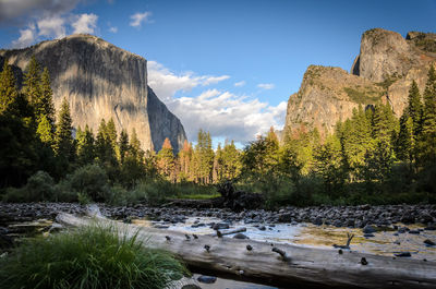 Scenic view of river by mountains against sky