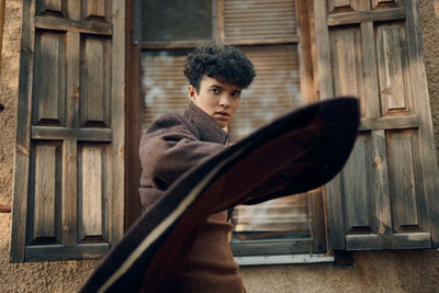Side view of young man looking through window