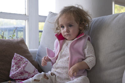 Little girl concentrate watching tv alone in her living room.