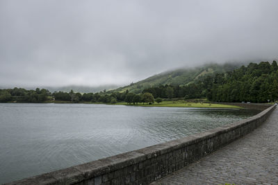 Scenic view of lake by mountains against sky