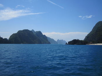 Scenic view of sea and mountains against sky