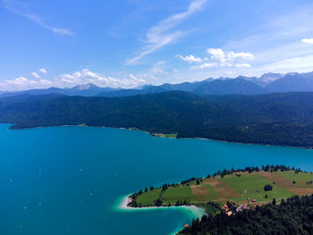 Scenic view of lake and mountains against blue sky