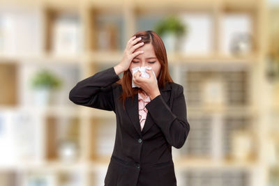 Businesswoman sneezing nose