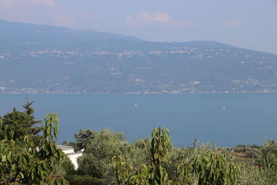 Scenic view of sea by mountains against sky