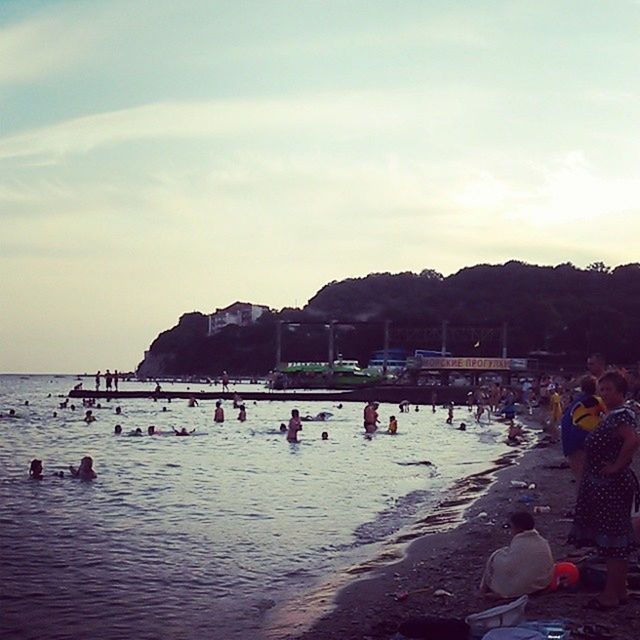 large group of people, beach, sea, water, mixed age range, vacations, sky, lifestyles, shore, leisure activity, person, tourist, men, sand, tourism, enjoyment, horizon over water, built structure, travel destinations