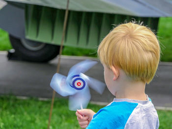 Rear view of boy holding pinwheel toy