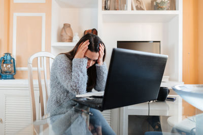 Young woman using mobile phone at home